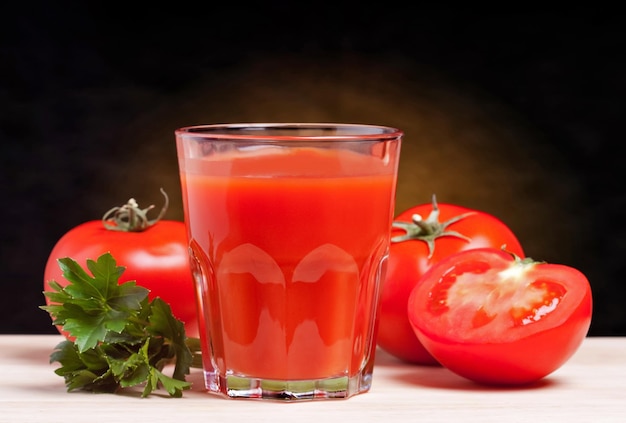 Pomodori freschi e un bicchiere pieno di succo di pomodoro