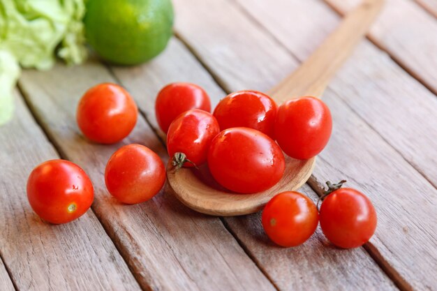 Pomodori freschi rossi sul cucchiaio di legno