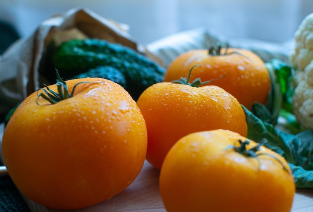 Pomodori gialli luminosi in goccioline d'acqua in primo piano