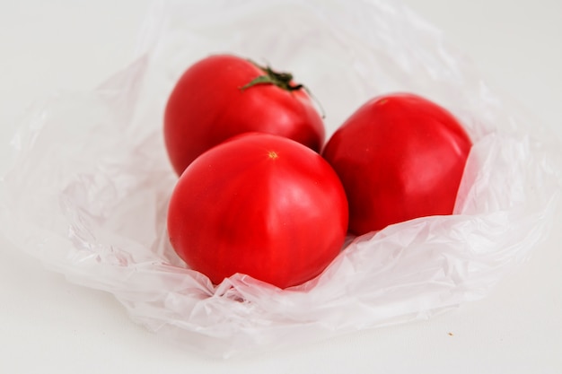 pomodori in un sacchetto di plastica su uno sfondo chiaro