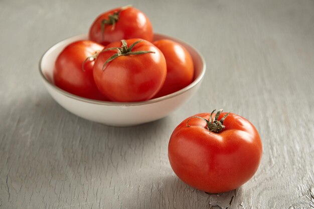 Pomodori in una ciotola su un fondo di legno