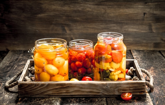 Pomodori marinati con spezie in un vecchio vassoio sulla tavola di legno.