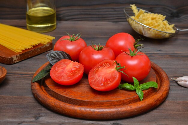 Pomodori maturi e ingredienti per la pasta per la preparazione degli spaghetti