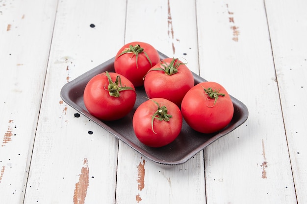 Pomodori maturi rossi su fondo di legno