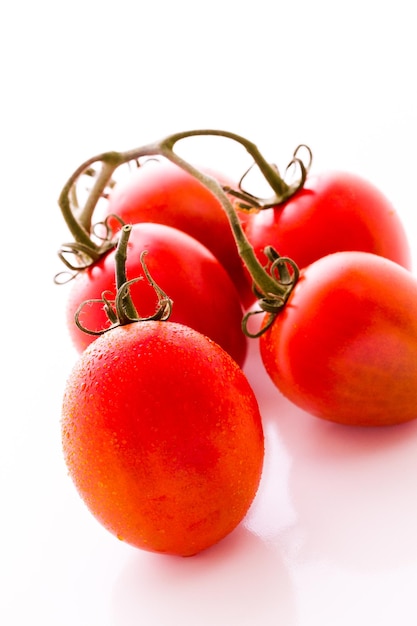 Pomodori Roma organici su sfondo bianco.