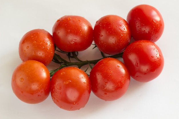 Pomodori rossi con foglie verdi. Vista dall'alto. sfondo bianco