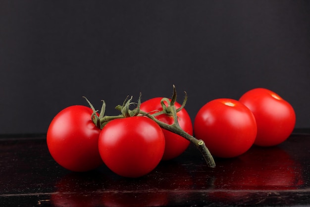 Pomodori rossi dolci succosi su sfondo nero Concetto di cibo sano Primo piano