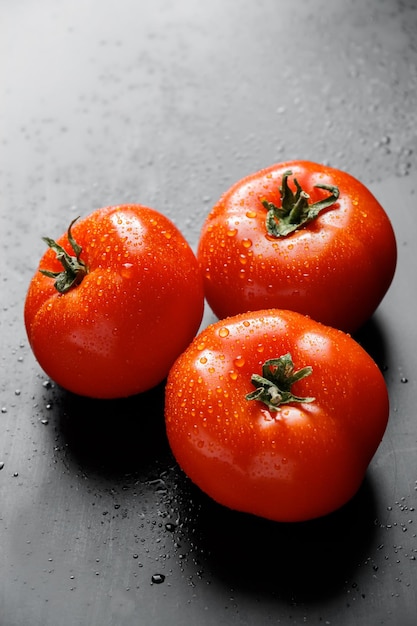 Pomodori rossi grandi con gocce d'acqua Verdure di stagione per una sana alimentazione