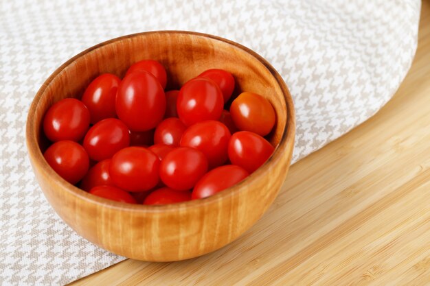 Pomodori rossi luminosi in una tazza di legno Pronto per cucinare in cucina