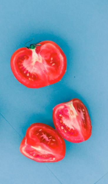 Pomodori rossi maturi freschi su sfondo blu cibo vegetale biologico
