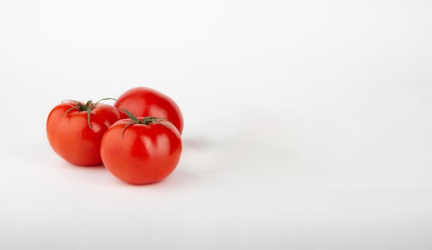 Pomodori rossi maturi su sfondo biancoCopiare lo spazio