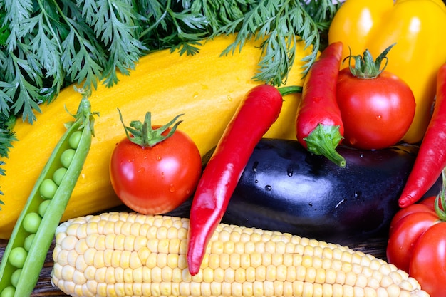 Pomodori rossi peperoncino piselli mais melanzane e paprika gialla vista dall'alto