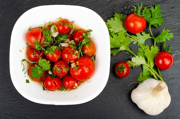 Pomodori sott'aceto con erbe e aglio. Foto dello studio.