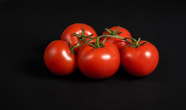 Pomodori succosi su una superficie nera