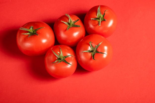 Pomodori succosi su una superficie rossa brillante