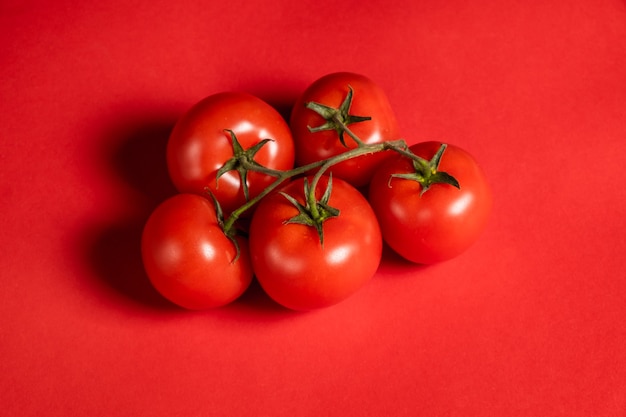 Pomodori succosi su una superficie rossa brillante