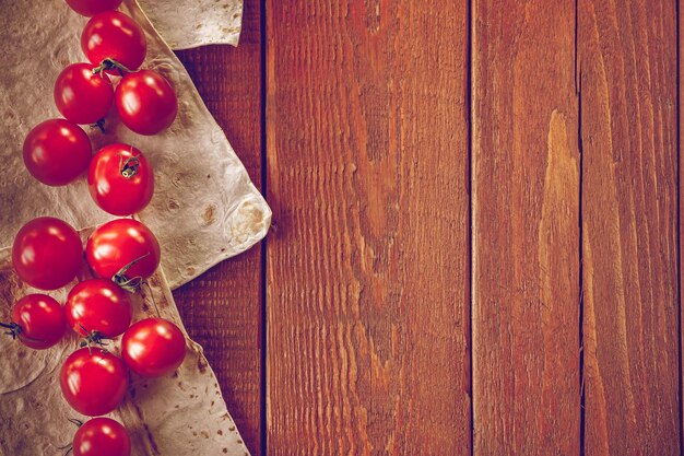 Pomodorini con pane lavico tonico su fondo di legno