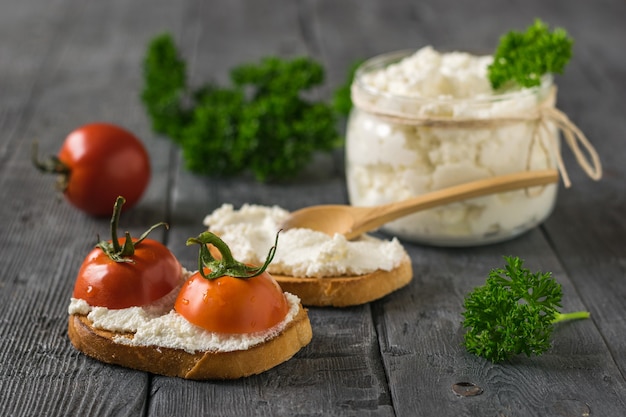 Pomodorini e ricotta su un tavolo di legno. Il concetto di una dieta sana.