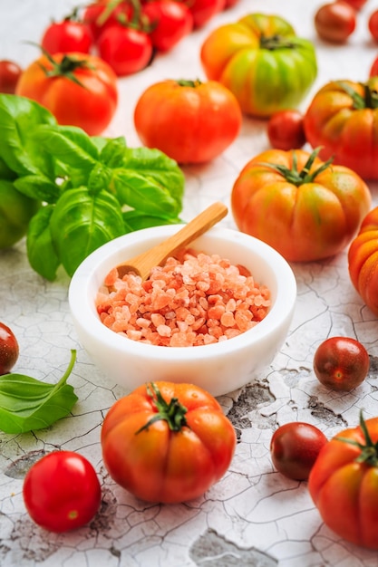 Pomodorini freschi con basilico e sale grosso da utilizzare come ingredienti da cucina