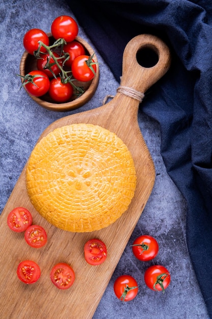 pomodorini freschi e formaggio su una tavola di pietra nera