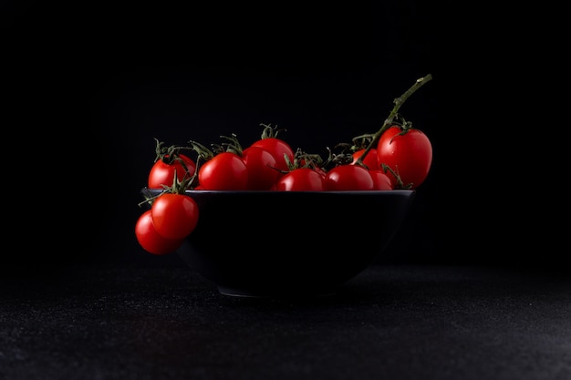Pomodorini in un piatto su uno sfondo scuro