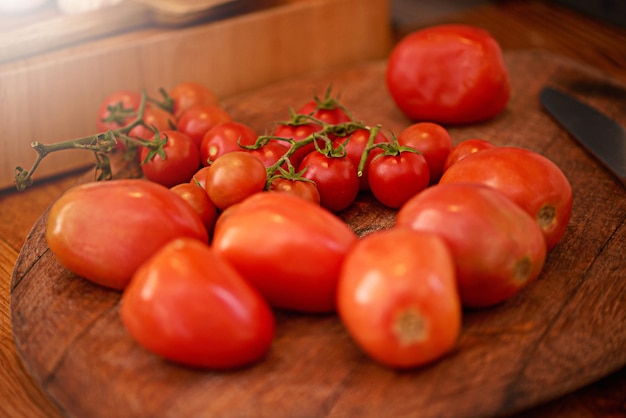 Pomodorini perfettamente carnosi Colpo di una prugna e pomodorini su un tavolo in una cucina