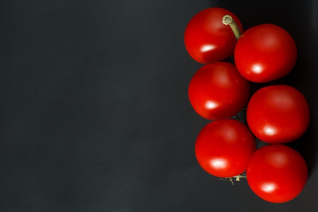 Pomodorini sul gambo pomodorini su sfondo nero