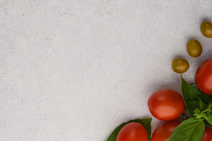 Foto pomodoro con basilico e olive su fondo di pietra bianco. sfondo di verdure con spazio di copia.