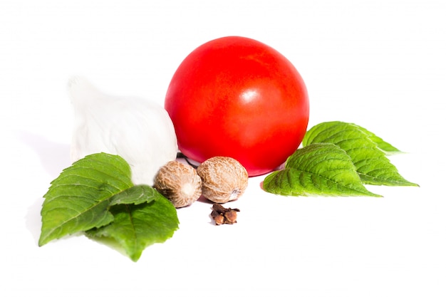 Pomodoro con pepe e aglio su sfondo bianco, composizione di pomodori e spezie vista dall&#39;alto