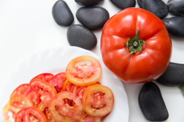 Pomodoro fresco con pomodoro a fette su sfondo bianco con spazio per il testo