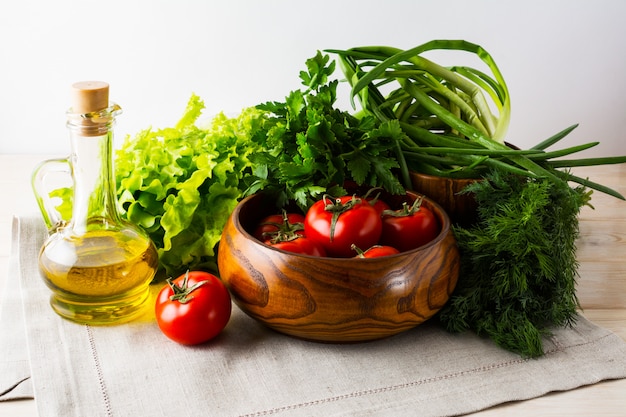 Pomodoro fresco in ciotola di legno e olio d'oliva