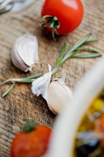 Pomodoro piccolo aglio e rosmarino su uno sfondo di legno vintage