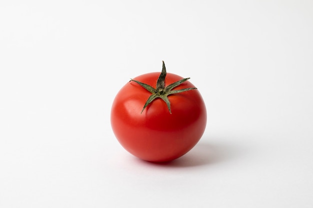 Pomodoro rosso fresco isolato su superficie bianca