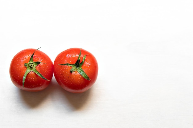 Pomodoro rosso maturo su fondo bianco.