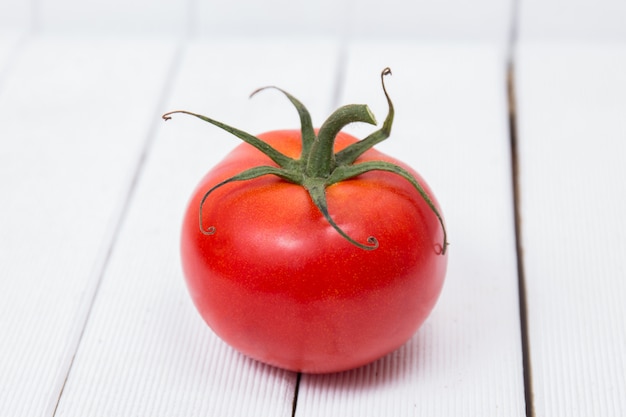 Pomodoro saporito su una priorità bassa bianca