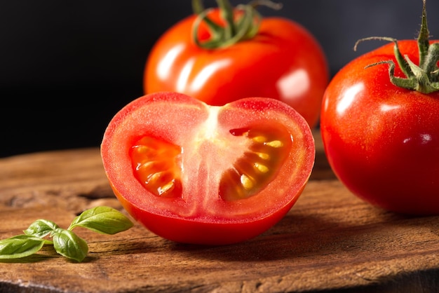 Pomodoro tagliato rosso su una tavola di legno