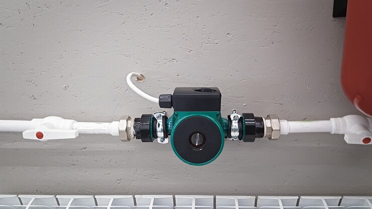 Pompa di circolazione del riscaldamento verde montata su un tubo Sistema di riscaldamento autonomo nel locale caldaia a casa