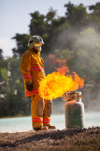 Pompiere con fuoco e tuta per proteggere i vigili del fuoco per addestrare i vigili del fuoco