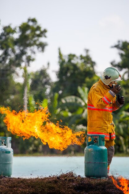 Pompiere con fuoco e tuta per proteggere i vigili del fuoco per addestrare i vigili del fuoco