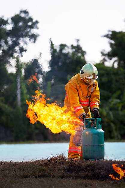 Pompiere con fuoco e tuta per proteggere i vigili del fuoco per addestrare i vigili del fuoco