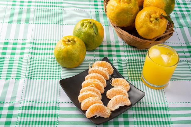 Ponkan arancione, fette di ponkan arancione su un piatto nero