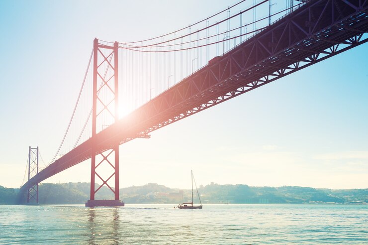 Foto ponte 25 aprile a lisbona, portogallo. paesaggio estivo. a questo punto il fiume tejo sfocia nell'oceano atlantico