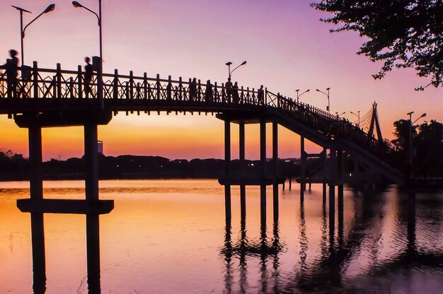 Ponte al tramonto .Vanilla sky in sfocatura e tonalità rosa con folla sul ponte. fotografia di silhouette