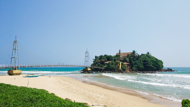 Ponte dalla spiaggia all'isola nell'oceano