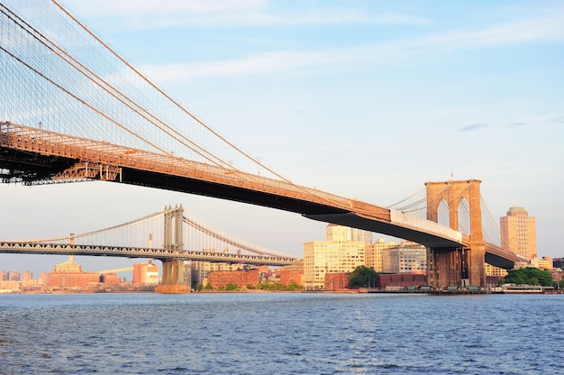 Ponte di Brooklyn sull'East River visto dal lungomare di New York City Lower Manhattan al tramonto.