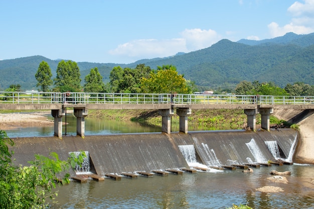 Ponte di cemento sopra la diga nel fiume. Che scorre dalle montagne