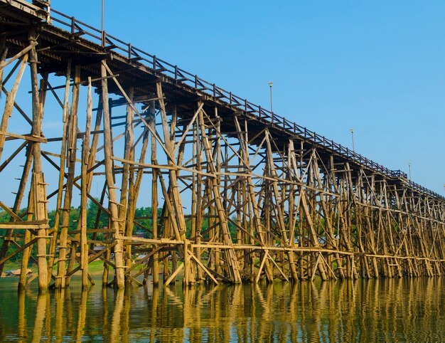 Ponte di legno con il fiume e montagna in Kanchanaburi Tailandia