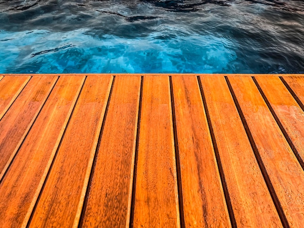 Ponte in legno a bordo piscina in primo piano per lo sfondo