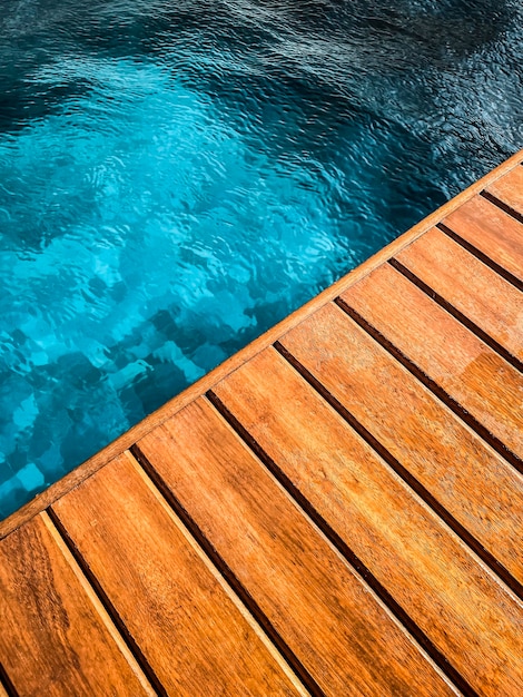 Ponte in legno a bordo piscina in primo piano per lo sfondo