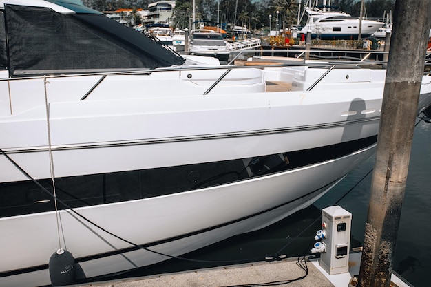 Ponte in teak di prua di un grande yacht bianco a motore di lusso in piedi sul parcheggio